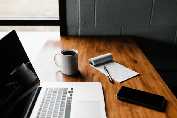 coffee cup and laptop on table